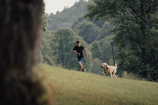 Young boy running with his dog in the lush green countryside of Suches, GA during spring.