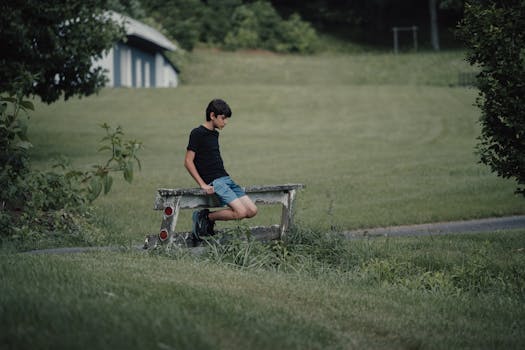 Young boy seated on a bench in a lush, green countryside setting in Suches, Georgia.