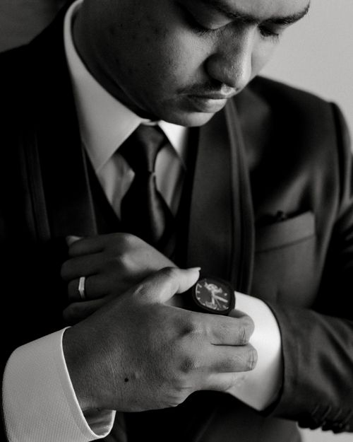 Free Stylish man in a suit adjusting his wristwatch in a black and white portrait. Stock Photo