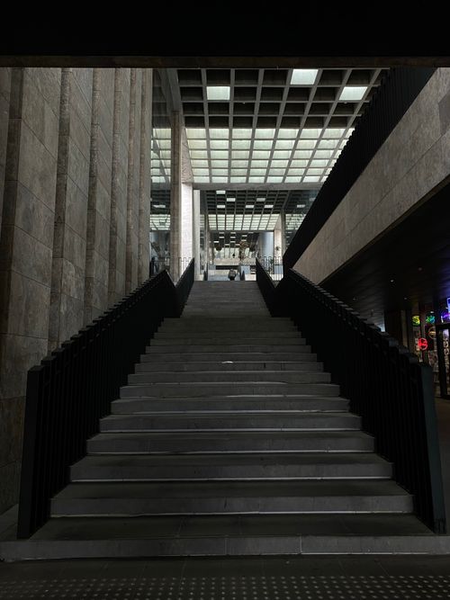 Free Contemporary staircase inside a modern building with concrete walls and grid ceiling. Stock Photo