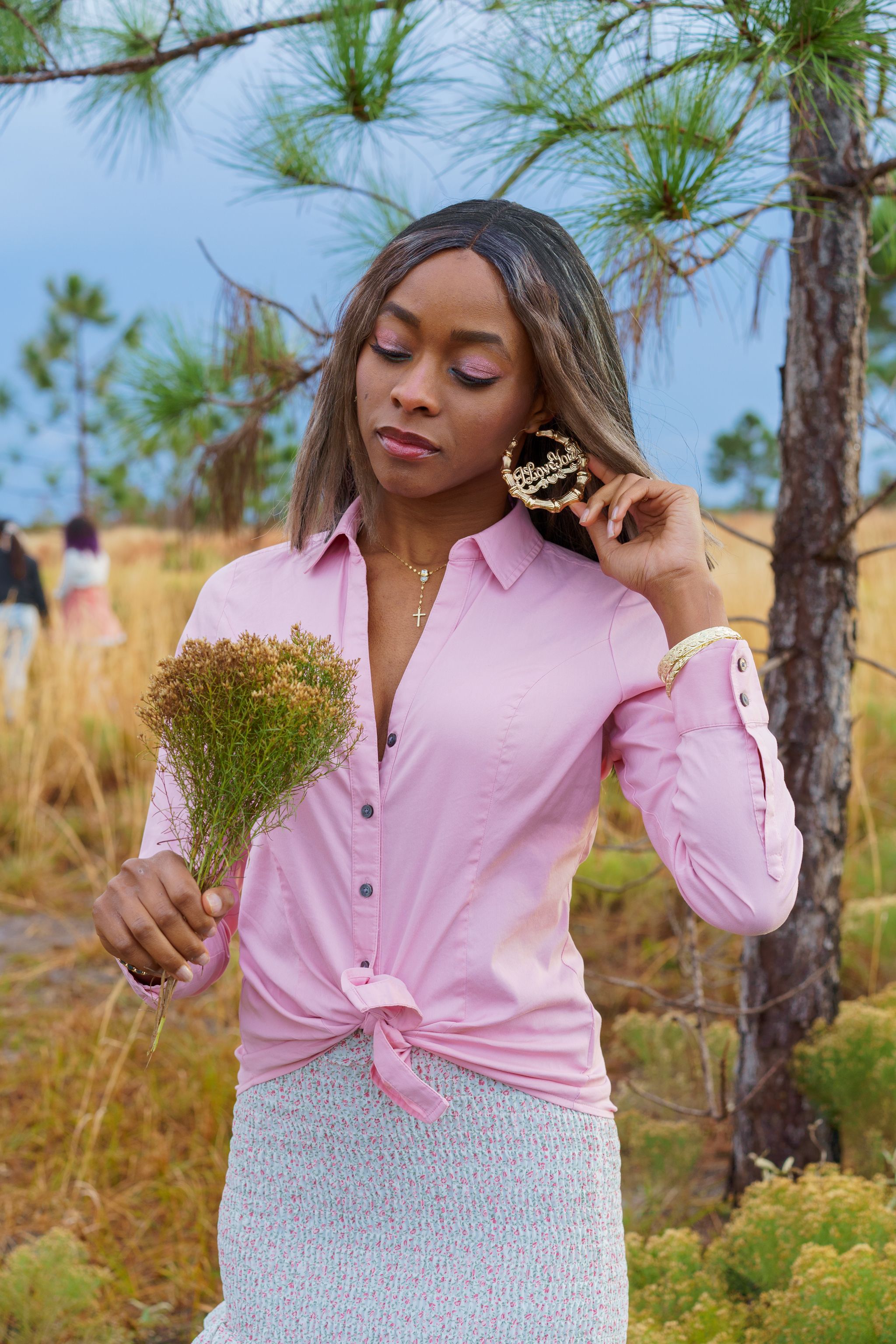 Young Woman Standing on a Field and Holding a Bunch of Flowers · Free ...