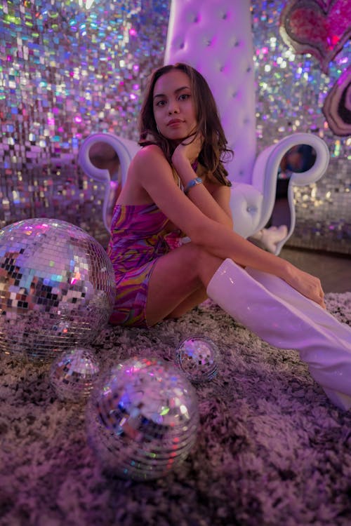 A woman sitting on a chair with disco balls