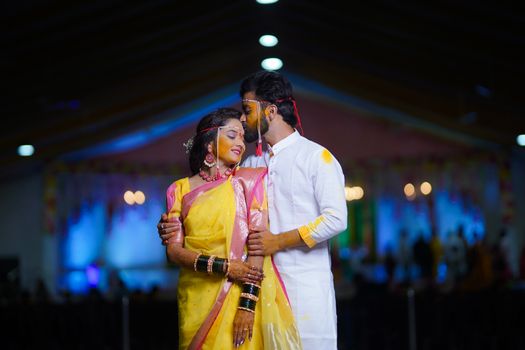 Indian couple celebrating love in vibrant traditional attire during a festive night.