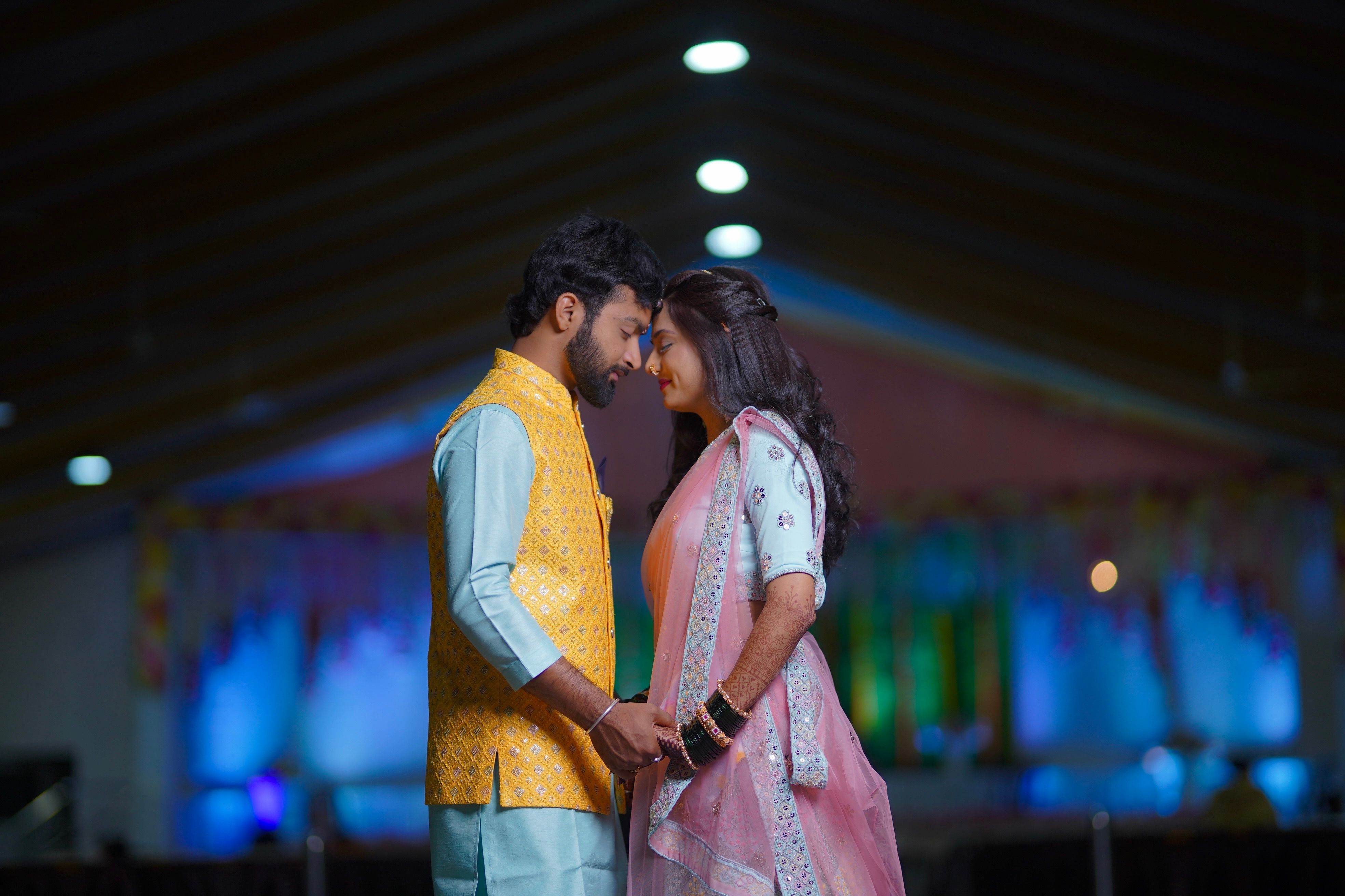 Indian couple in traditional clothing sharing a romantic moment indoors — true image example