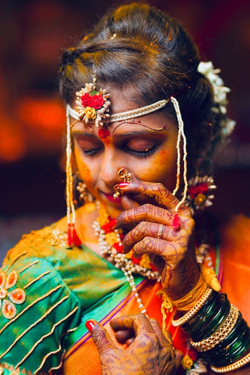 A woman in traditional indian attire with her hands on her face