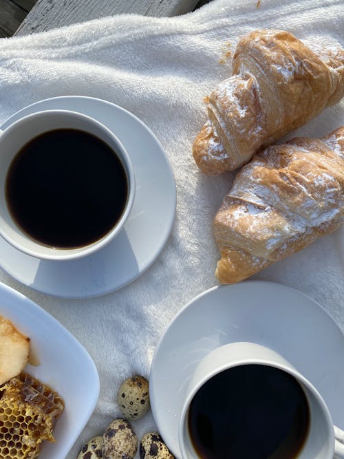 Free A white towel with coffee and croissants on it Stock Photo