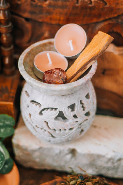 A small pot with candles and a wooden spoon