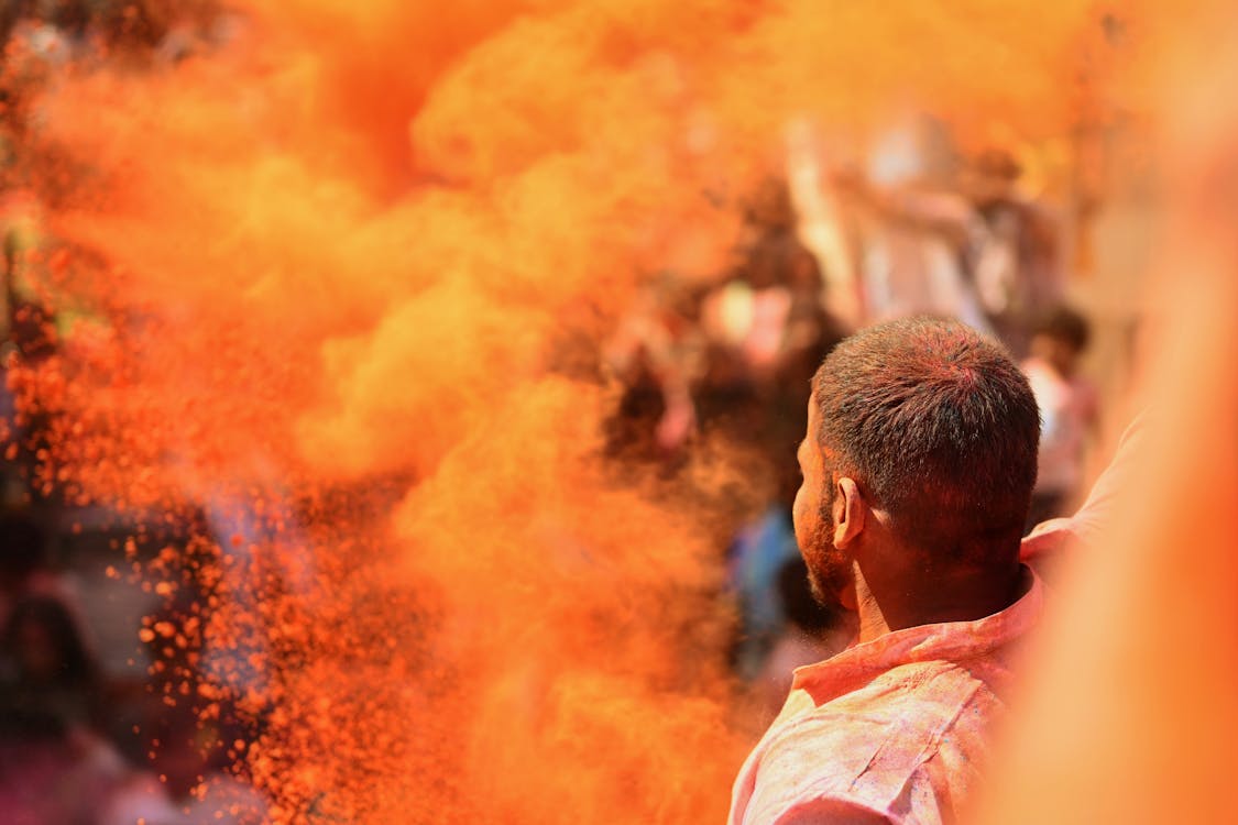 A man is covered in colored powder during holi