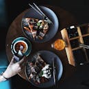 木桌上摆放着华夫饼、卡布奇诺和果汁的顶视图，供人享用美味的早餐