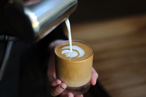 Photo of Person Pouring Milk In Coffee