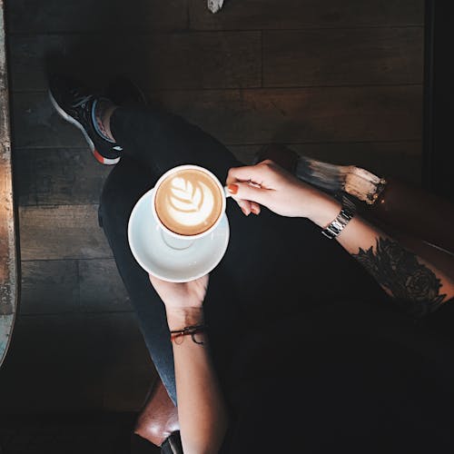 Draufsichtfoto Der Person, Die Kaffeetasse Hält