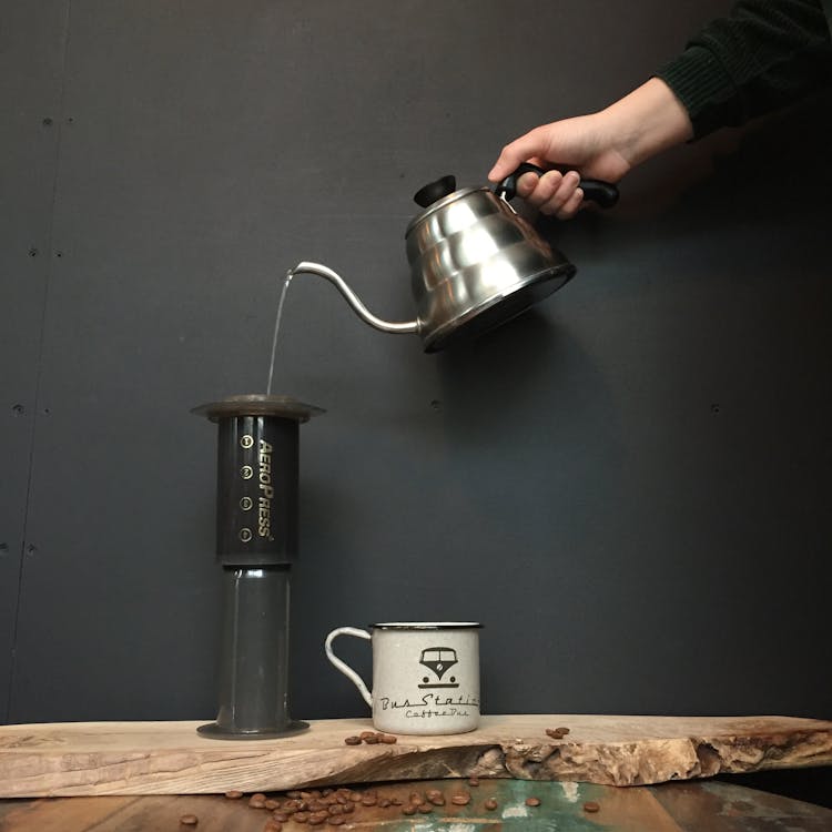 Free Person Pouring Liquid on Black and Brown Container Stock Photo