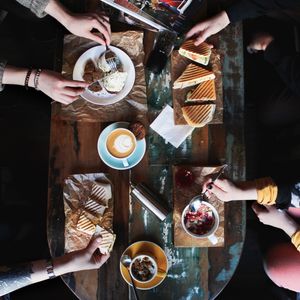 Coffee cups and pastries on a worn wooden table — photo by Viktoria Alipatova on Pexels