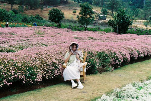 A woman sitting in a chair in a field of flowers