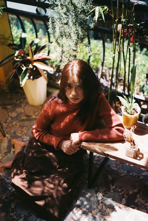 A woman sitting on the ground with a potted plant