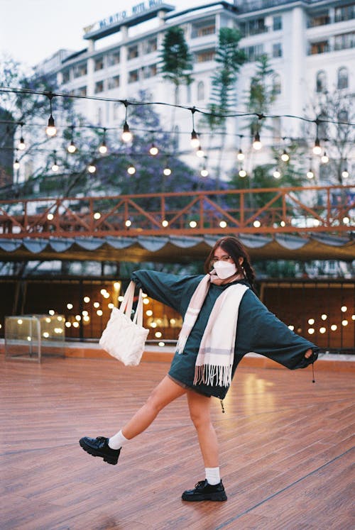 A woman in a mask and scarf is dancing