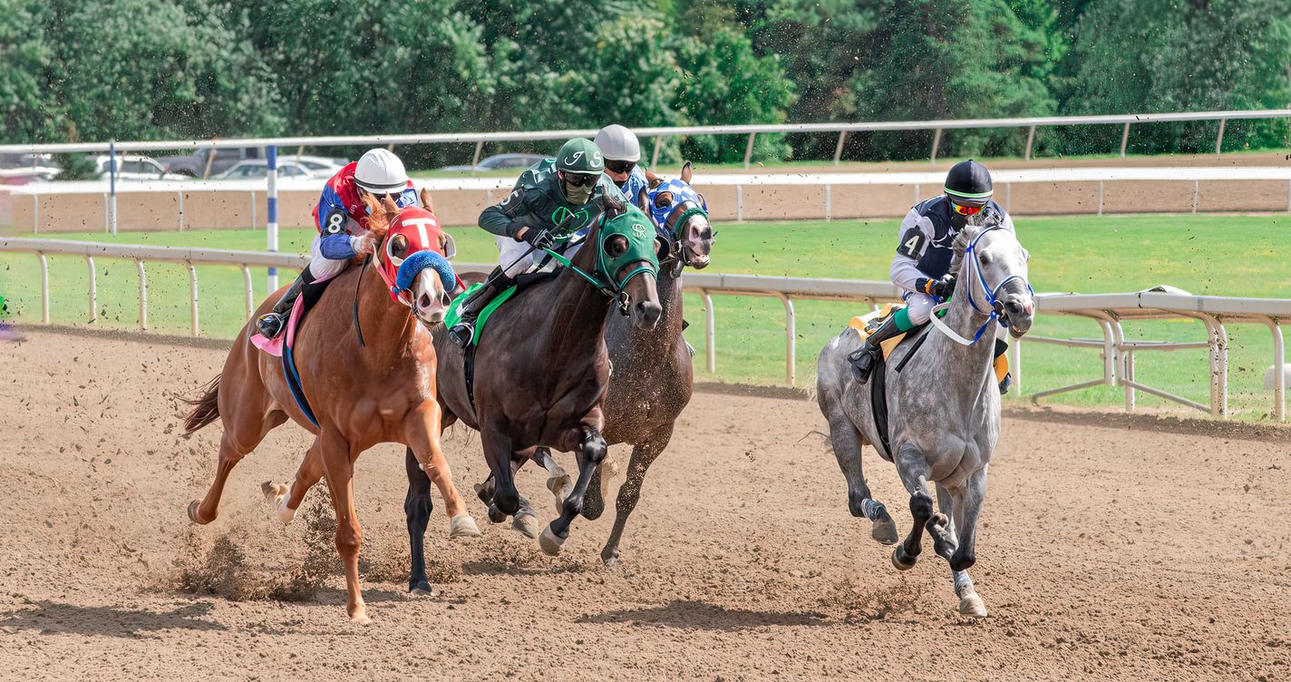 Jockeys et chevaux de course lancés avec intensité sur une piste, peloton compact en pleine course