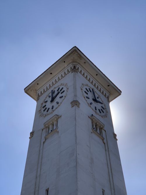 Free Imposing white clock tower in Casablanca, Morocco, set against a clear blue sky. Stock Photo