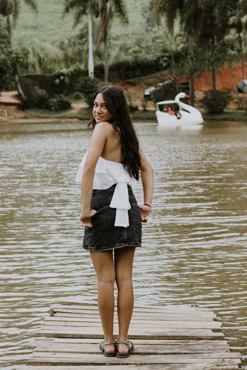 A woman standing on a dock in front of a lake
