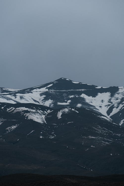 A snow covered mountain with a dark sky