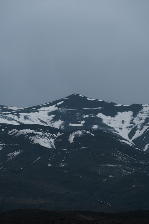 Free Dramatic snow-covered mountain landscape in Mashhad, Iran, with overcast sky. Stock Photo