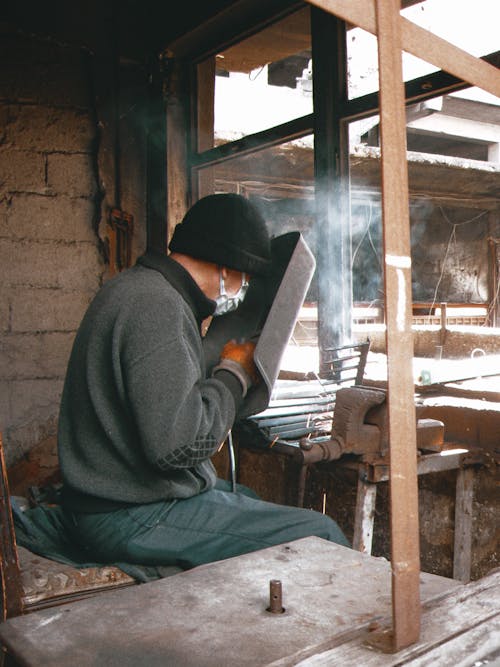 A man working on a metal piece in a workshop