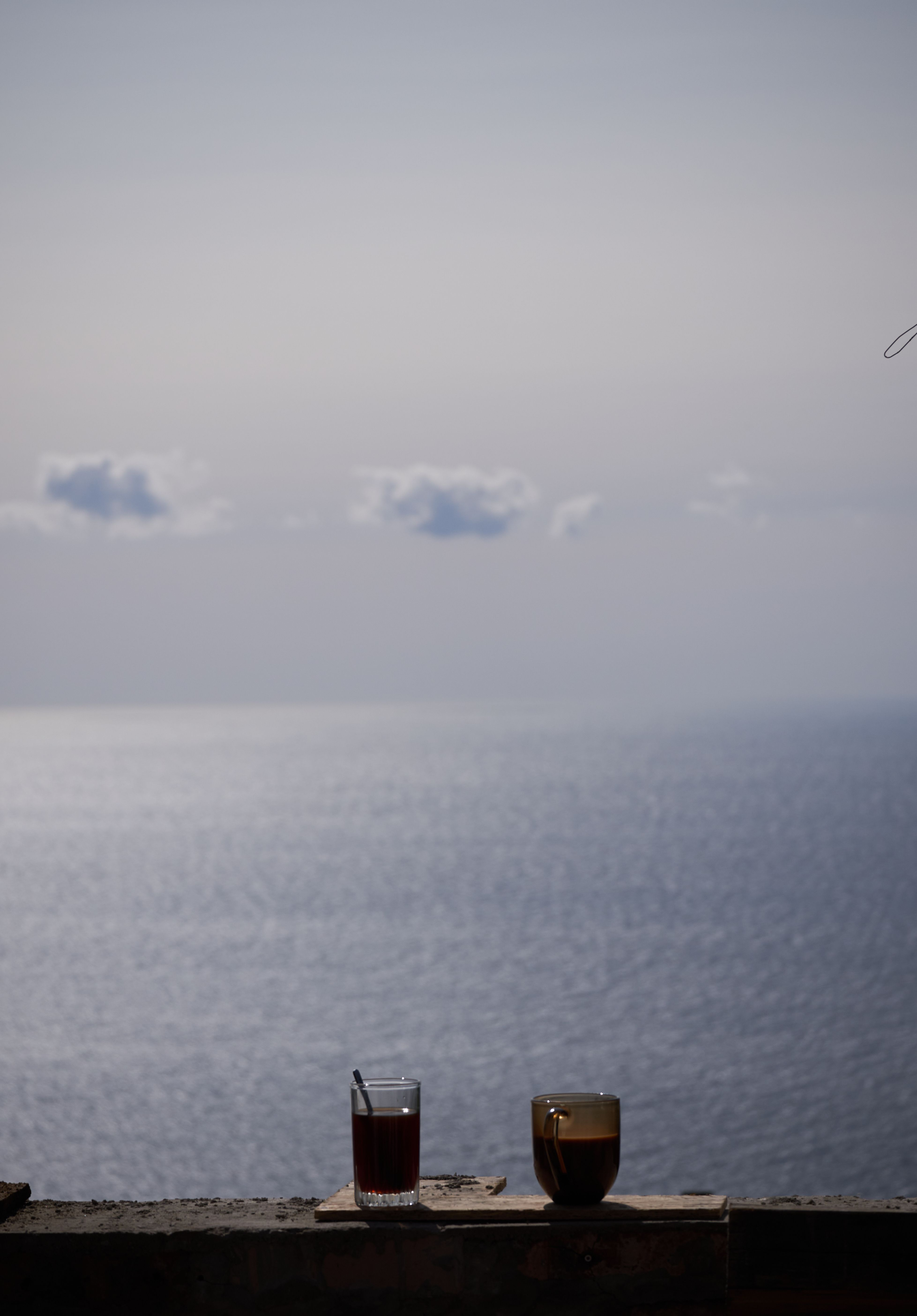 Tranquil ocean view with beverages against a calm, serene backdrop.