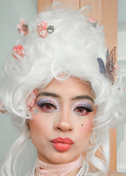 A woman with white hair and a flower headpiece