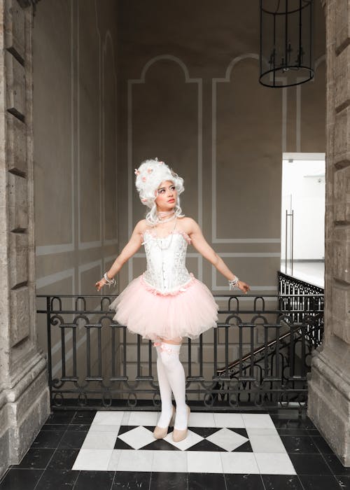 A woman in a pink tutu posing on a staircase