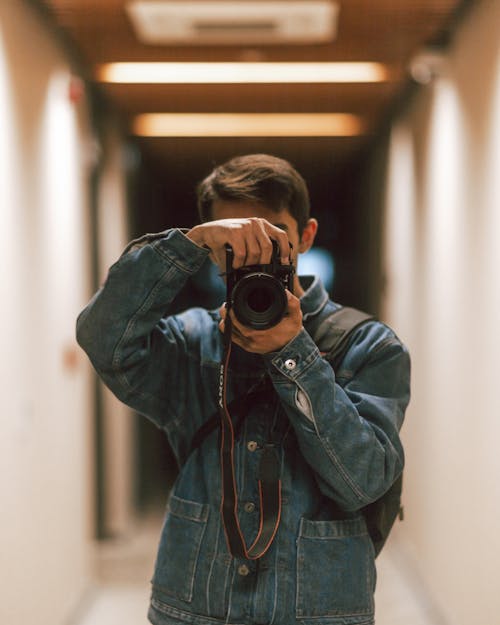 A man taking a photo in a hallway