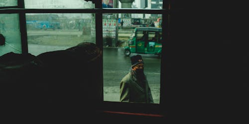 A man standing in front of a window looking out