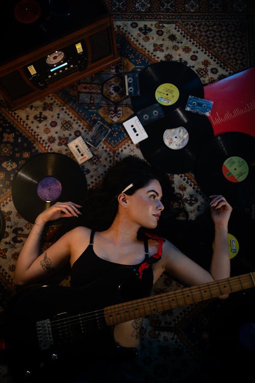 A woman laying on the floor with a guitar