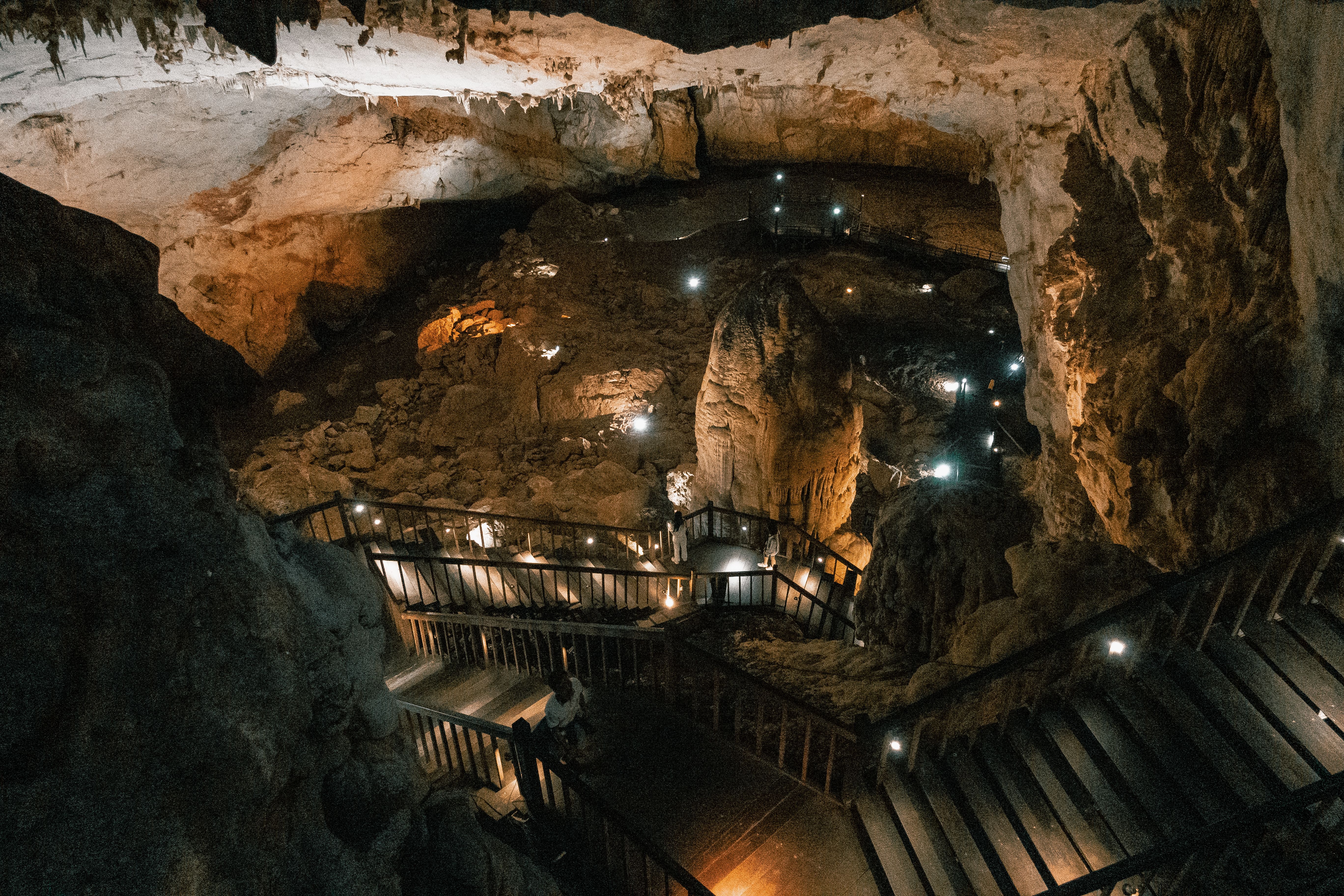 A stunning view of a cave with illuminated pathways and natural rock formations.