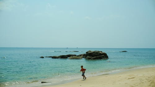 A person running on the beach near the ocean