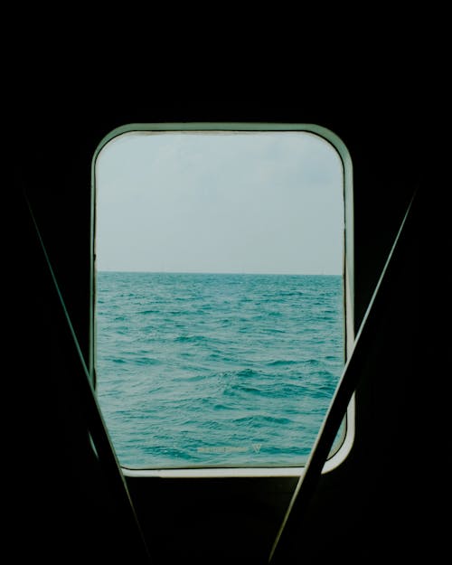 A view of the ocean from a window on a boat