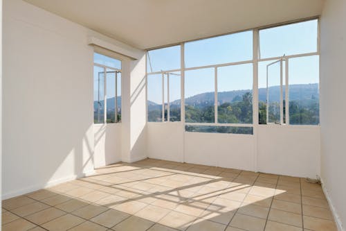 Empty room with large windows and mountains in the background