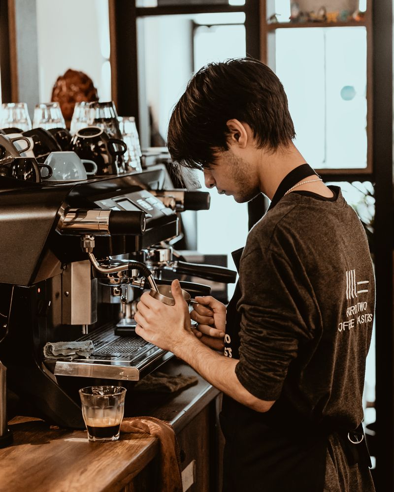 Barista pulling an espresso shot at a specialty coffee shop