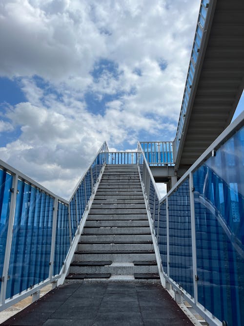 A stairway with blue railing and white steps