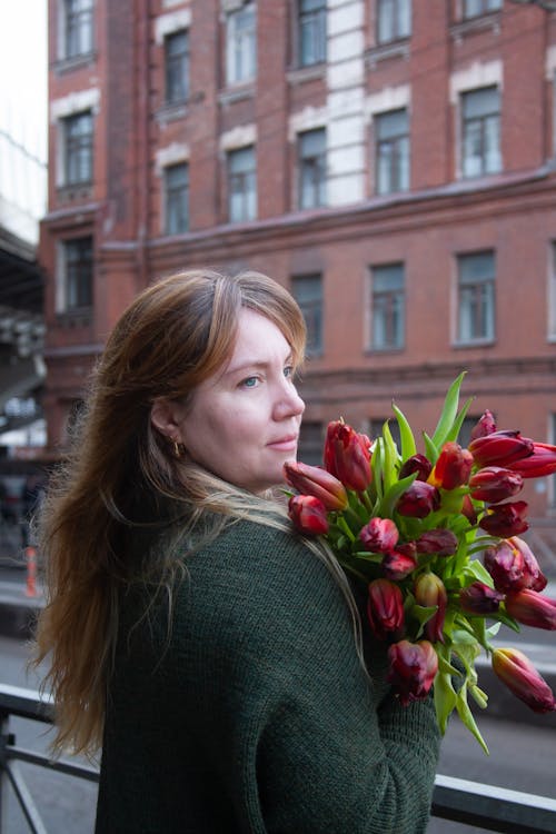 A woman holding a bouquet of red tulips