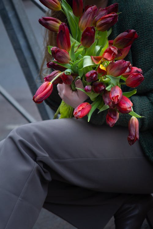 A woman holding a bunch of flowers in her hands