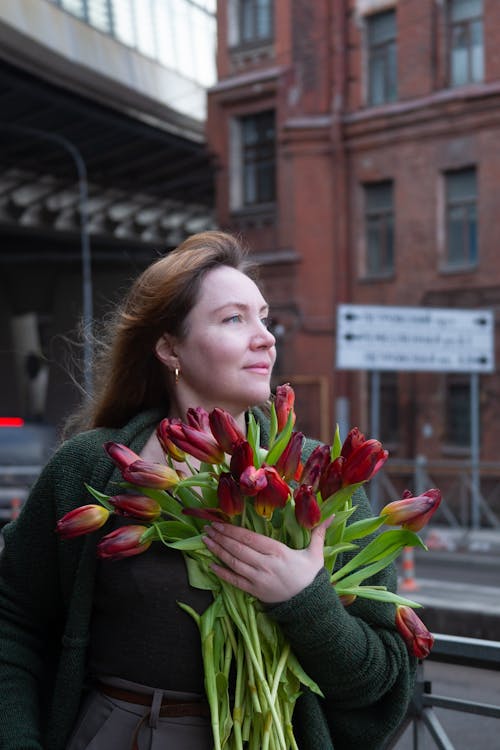 A woman holding a bouquet of red tulips