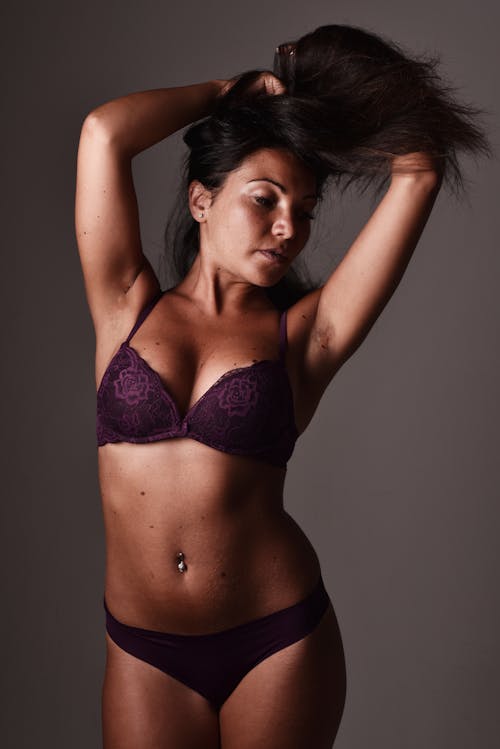 A woman in purple lingerie posing for a photo