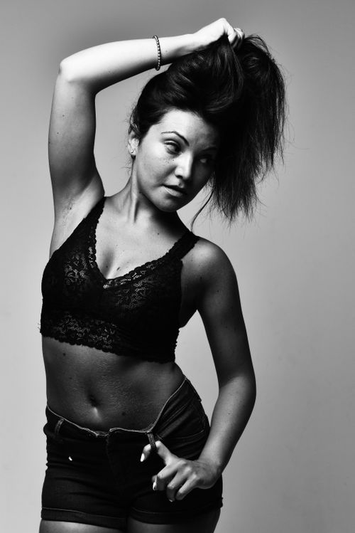 Free Artistic black and white photo of a woman posing in a lace top and denim shorts. Stock Photo