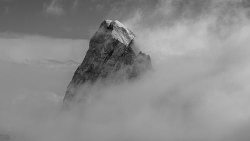 A black and white photo of a mountain in the clouds