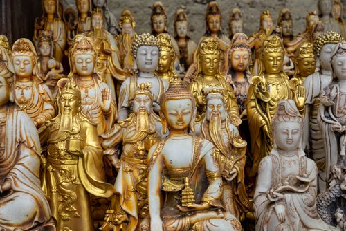 Free Exquisite collection of golden and stone Buddha statues showcasing traditional craftsmanship. Stock Photo