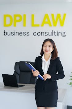 Confident woman in a business suit standing in consulting office with a clipboard.