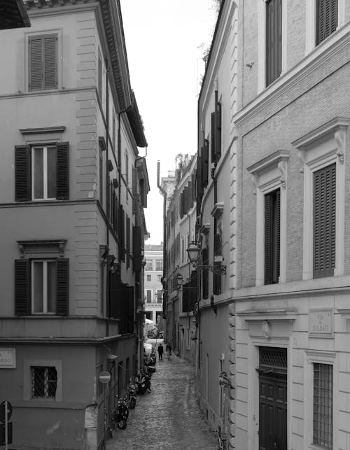 A black and white photo of a narrow street