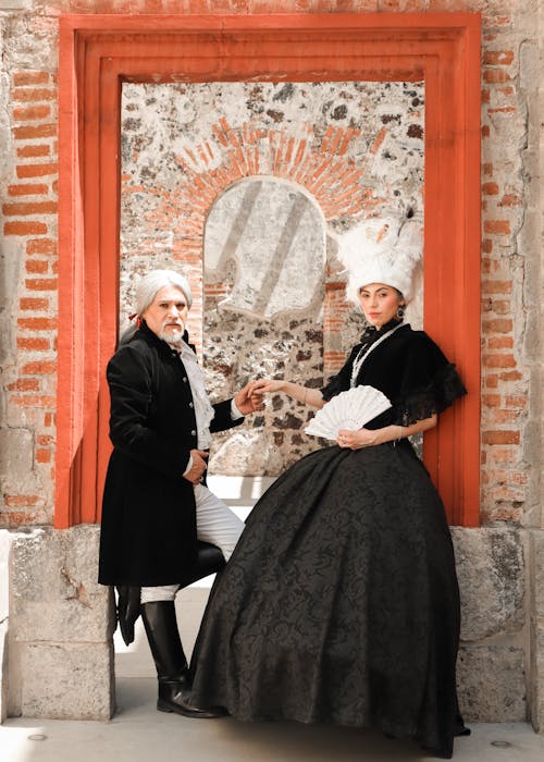 Man and Woman in Period Costumes Standing and Holding Hands 