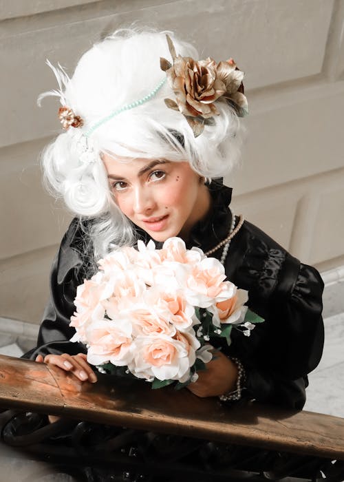 A woman with white hair and flowers on her head
