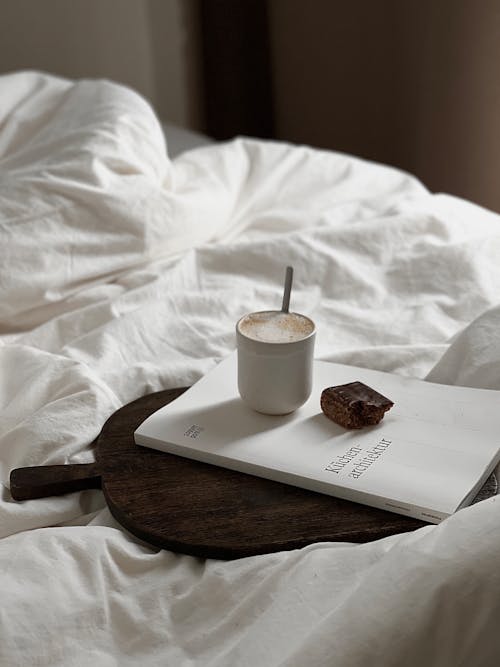 Free Coffee and Chocolate on Book on Bed Stock Photo